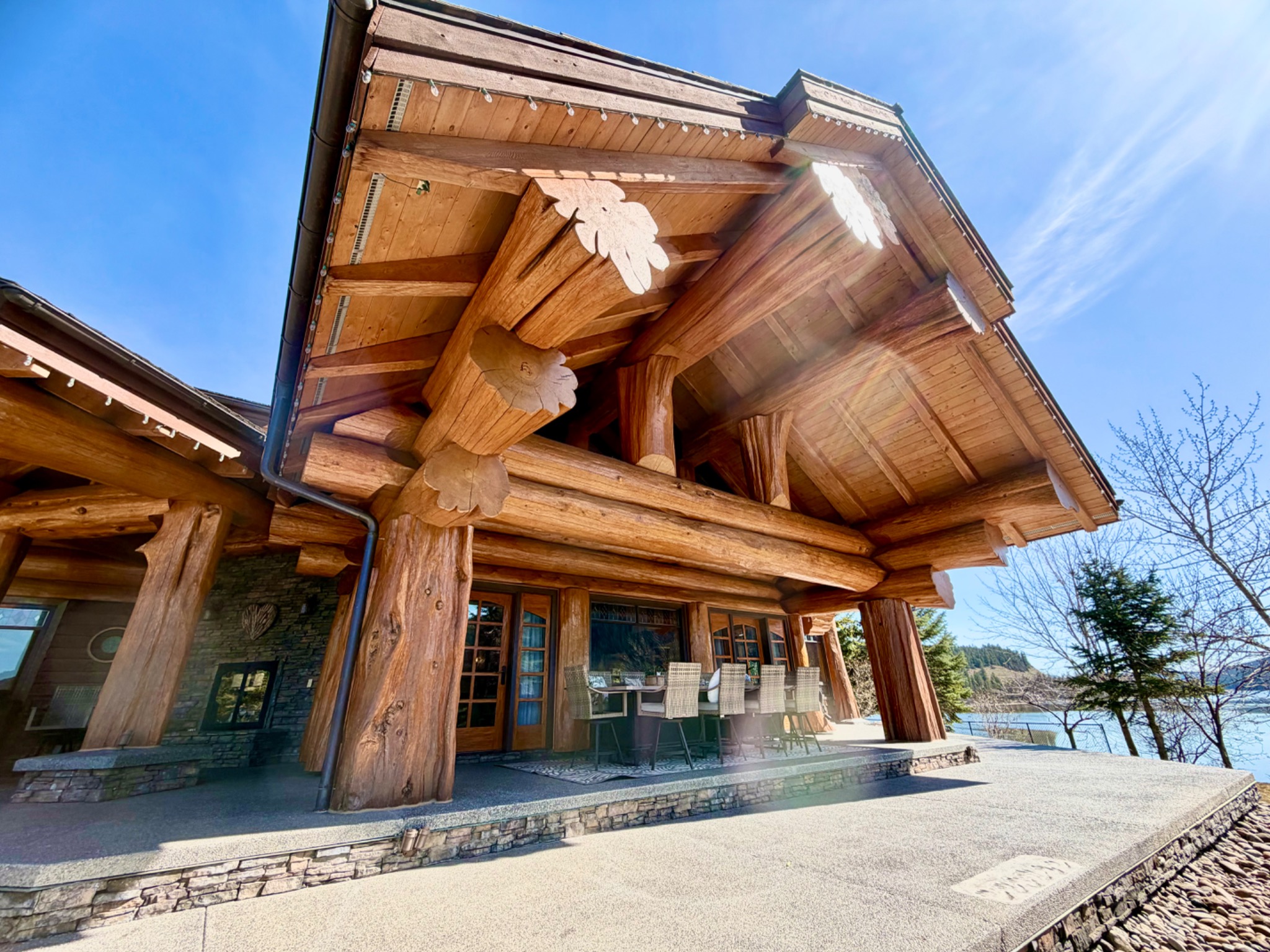 Close view of massive finished timber posts and beams meeting beneath a sculpted log home roof
