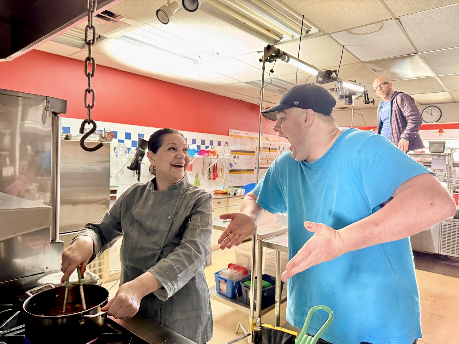 Two participants talking together while cooking in a kitchen