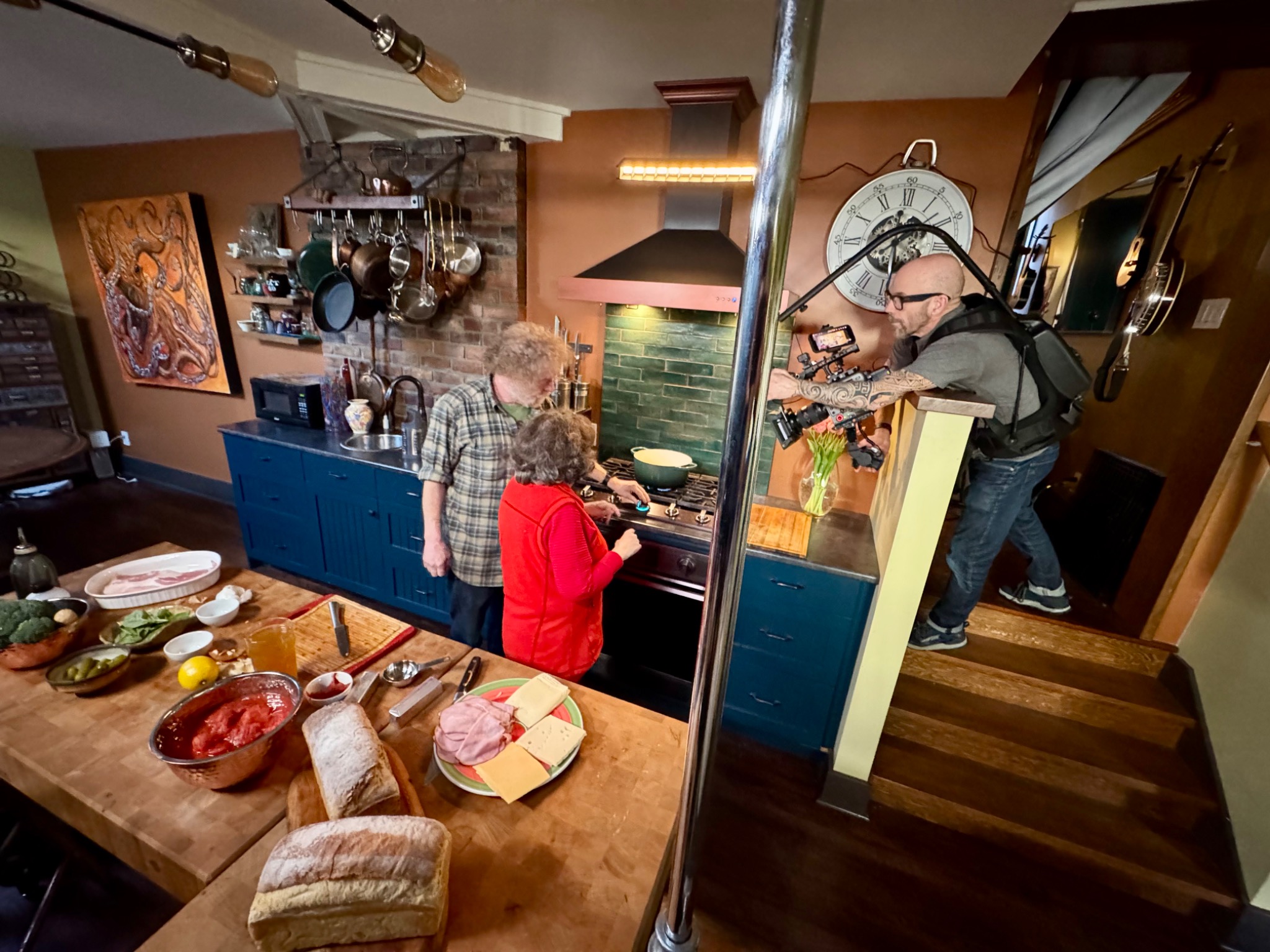 Crew filming participants cooking together in a kitchen